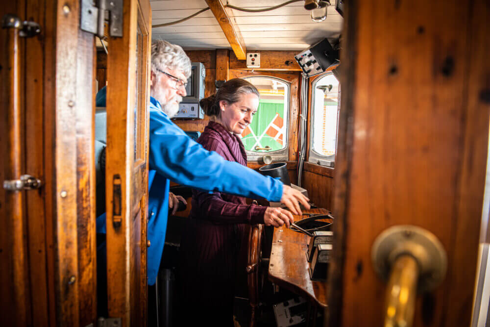 Kvinde får en rundvisning på båden i Fiskeriets Hus