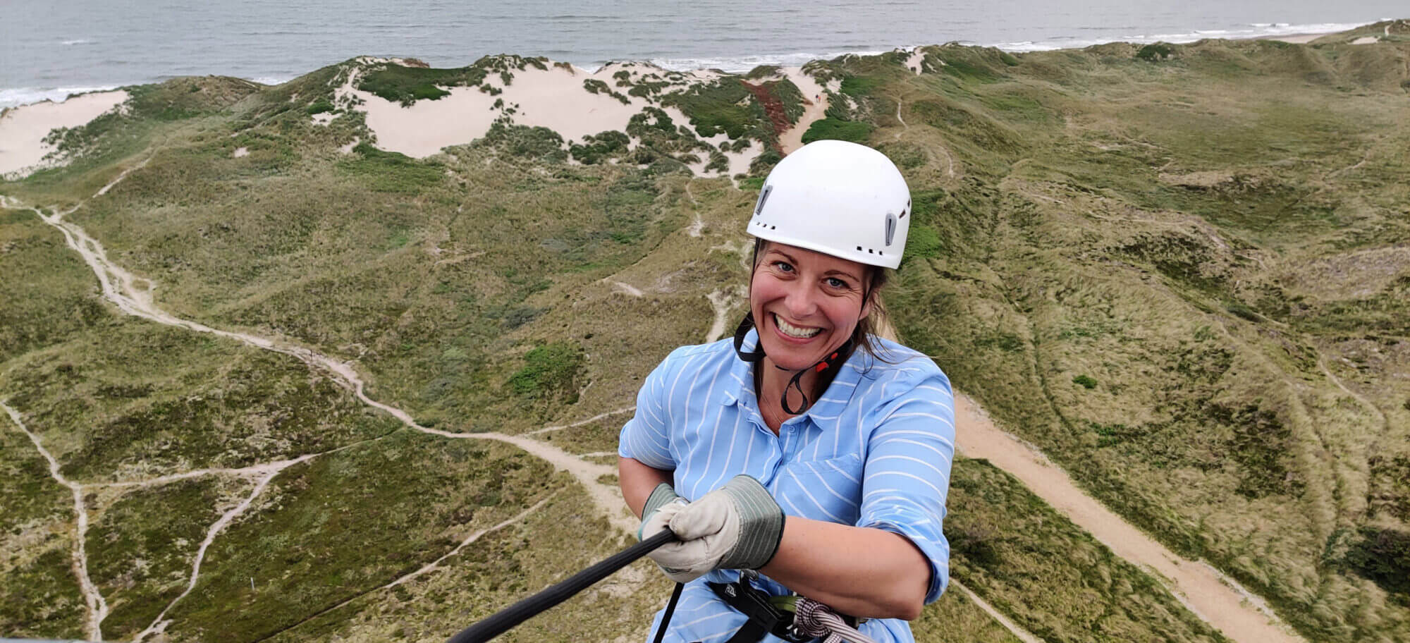 Kvinde prøver rappelling ned fra Lyngvig Fyr